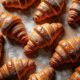 Croissants et pains au chocolat frais sur une table farinée